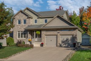 Front view of home with stone and vinyl front, concrete walkway and covered verandah | 101 Summerhill Row, Fredericton NB E3G 0E8 | Executive 2-Storey Home For Sale In West Hills