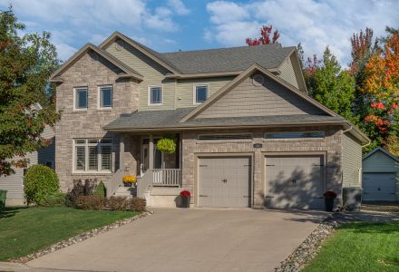 Front view of home with stone and vinyl front, concrete walkway and covered verandah | 101 Summerhill Row, Fredericton NB E3G 0E8 | Executive 2-Storey Home For Sale In West Hills